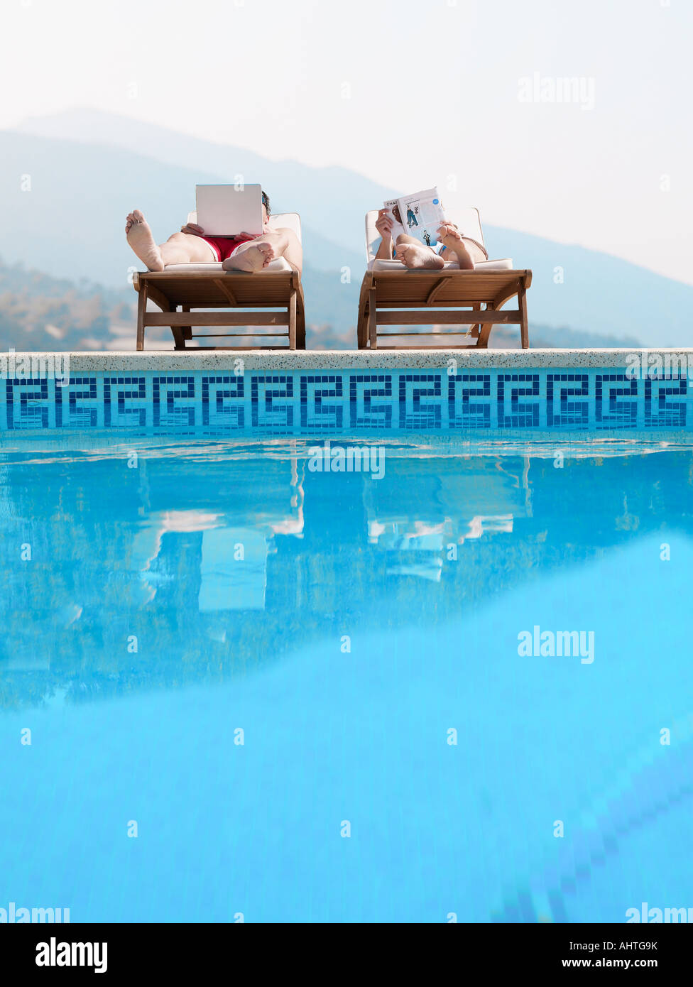 Matura a prendere il sole in piscina, Uomo con laptop Foto Stock