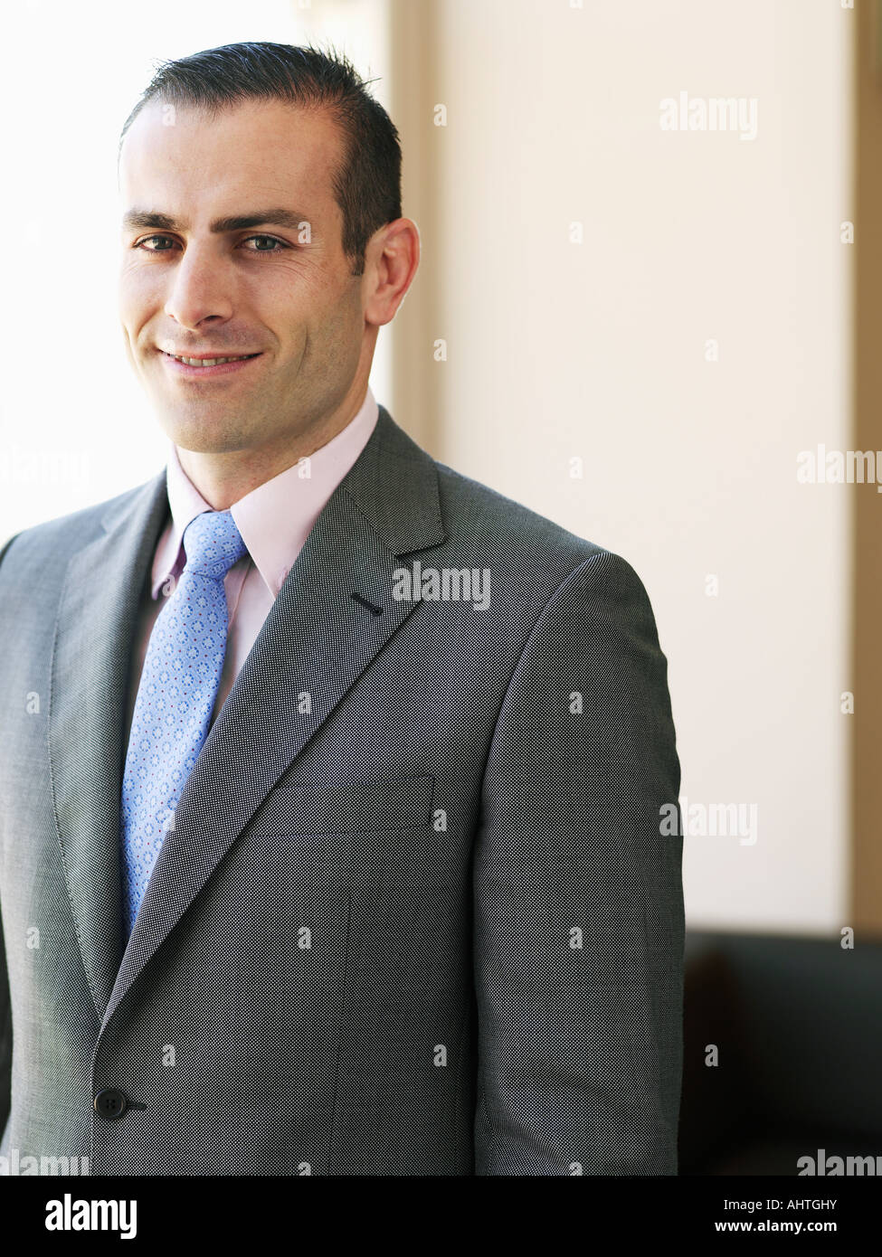 Imprenditore in piedi in ufficio, sorridente, ritratto Foto Stock