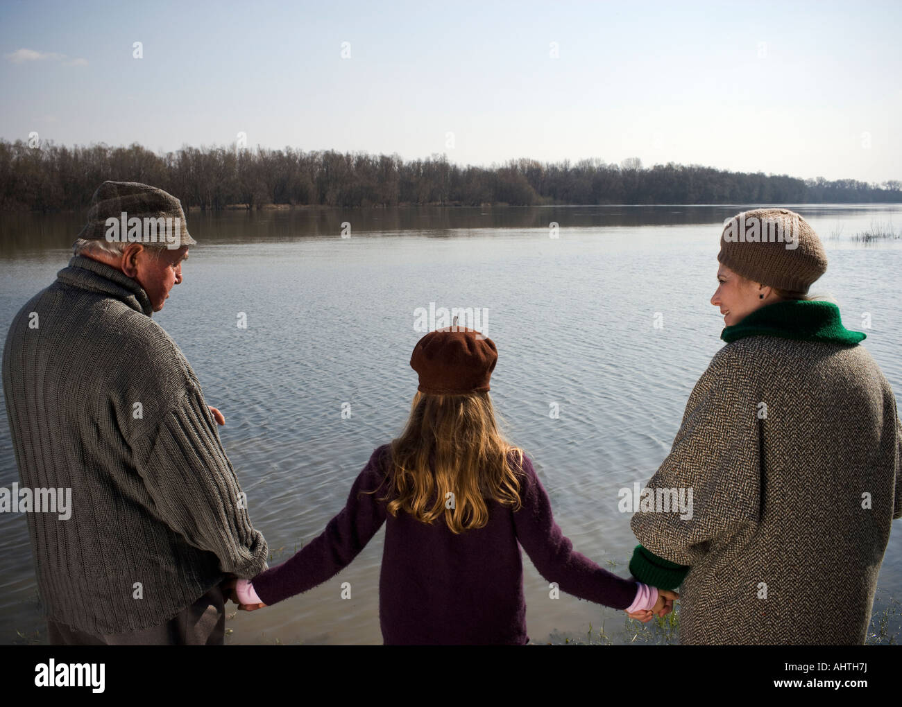Nonni tenendo le mani con il nipote (10-12) dal fiume Foto Stock