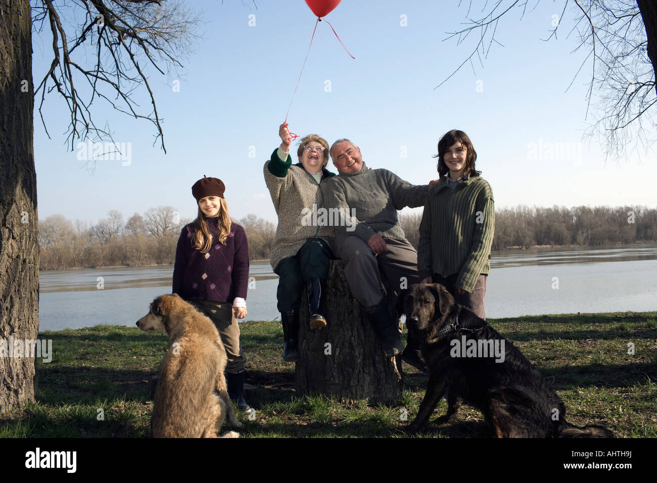 Nonni, nipote (12-14) e nipote (10-12) con due cani dal fiume Foto Stock