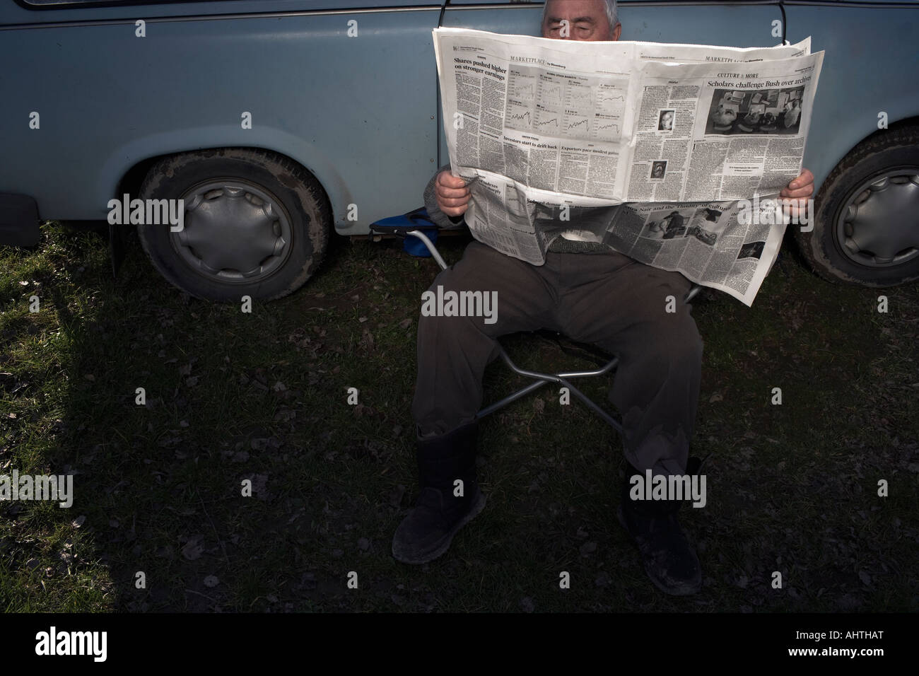 Senior uomo seduto in auto quotidiano di lettura Foto Stock