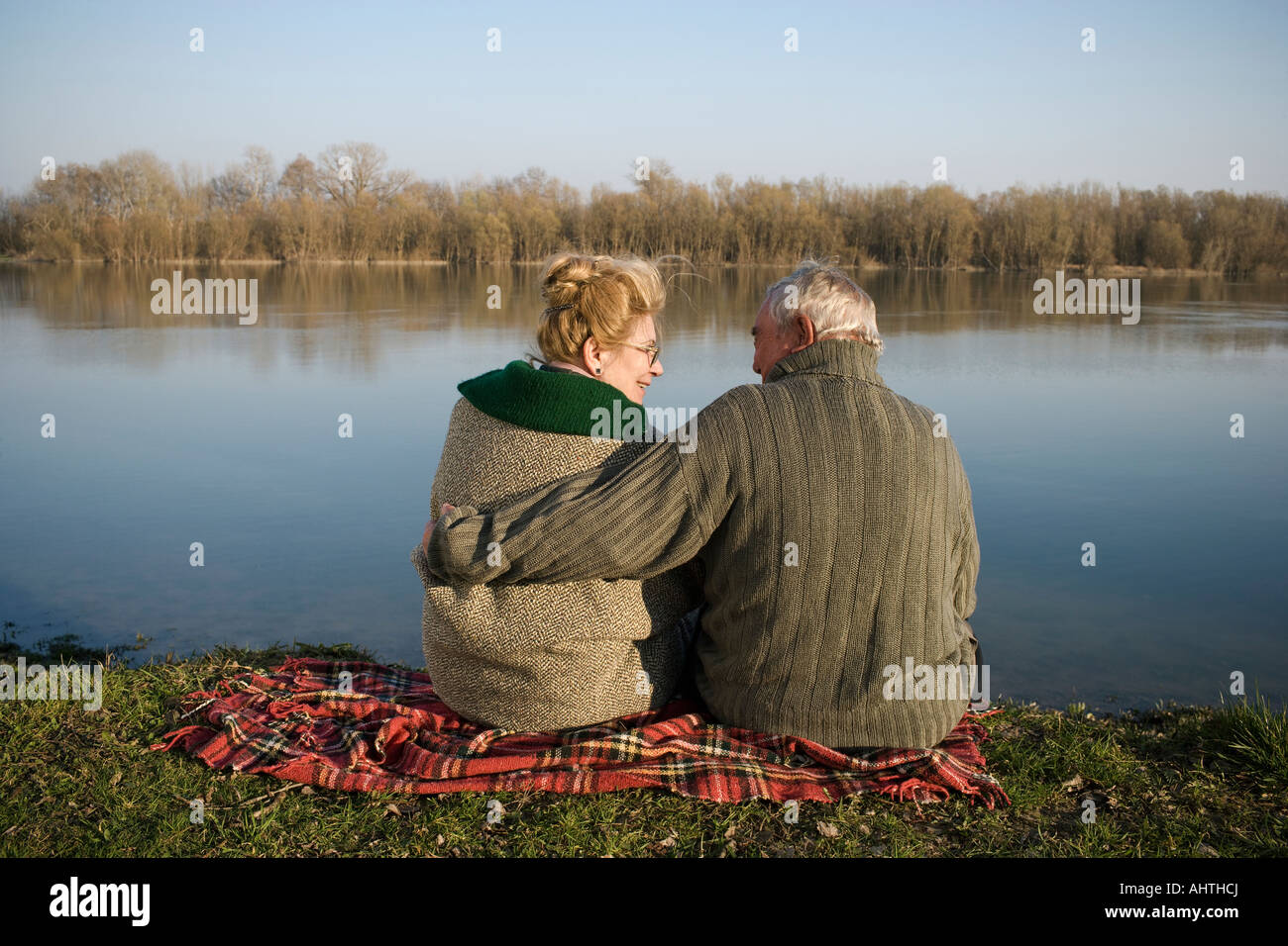 Coppia senior seduti sul tappeto da fiume, vista posteriore, Donna sorridente Foto Stock