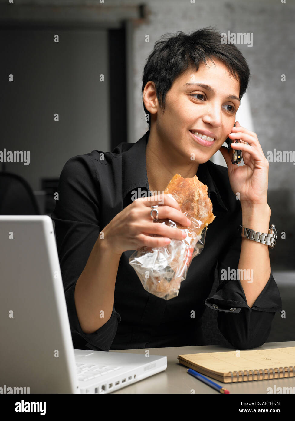 Imprenditrice parlando al telefono mentre avente uno snack. Bruxelles, Belgio. Foto Stock