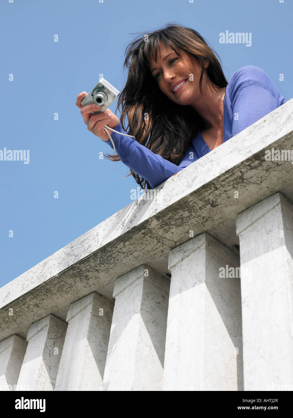 Donna sul balcone prendendo fotografie con una fotocamera digitale. Venezia, Italia. Foto Stock