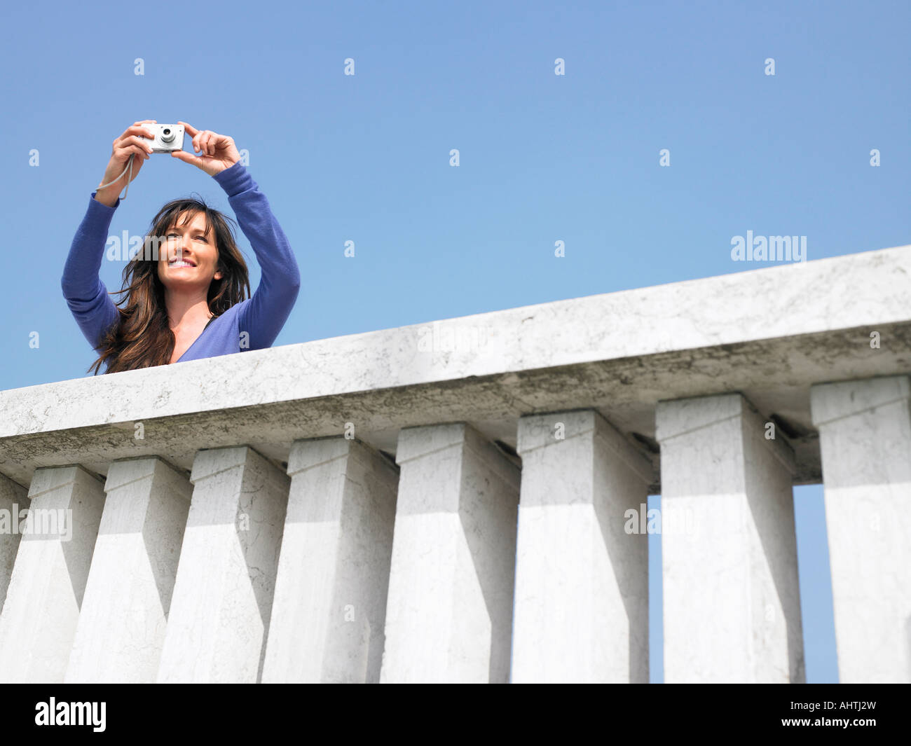 Donna sul balcone prendendo fotografie con una fotocamera digitale. Venezia, Italia. Foto Stock