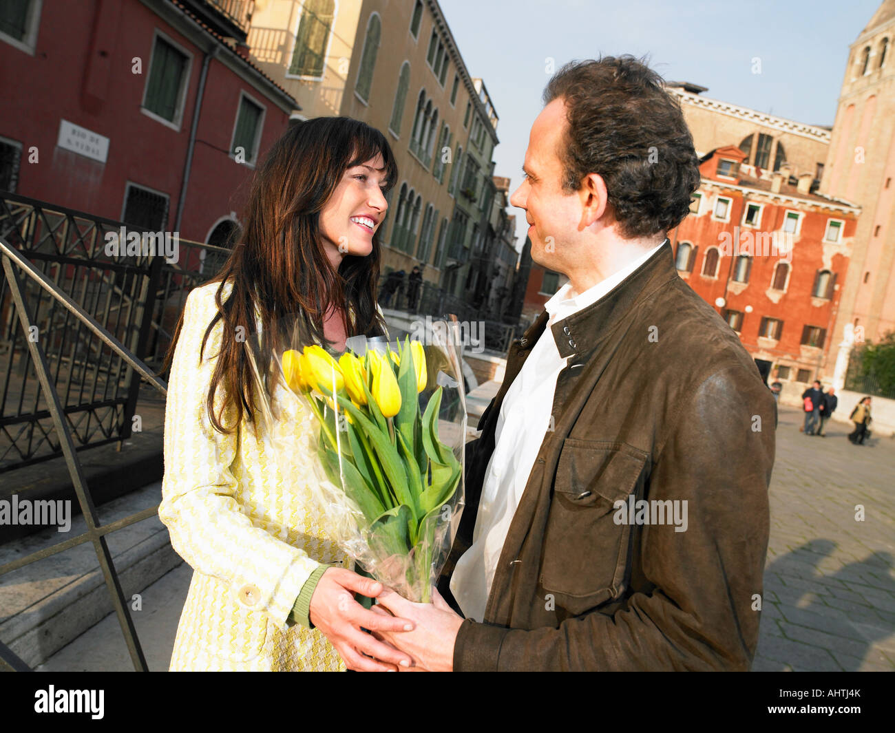 L uomo dando ai fiori di donna. Venezia, Italia. Foto Stock