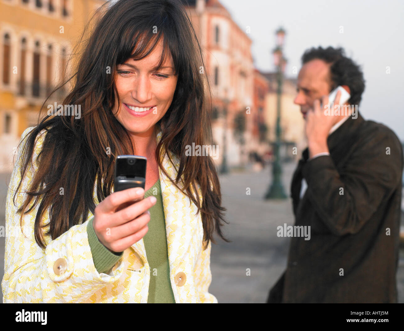 L uomo e la donna utilizzando i telefoni cellulari. Venezia, Italia. Foto Stock