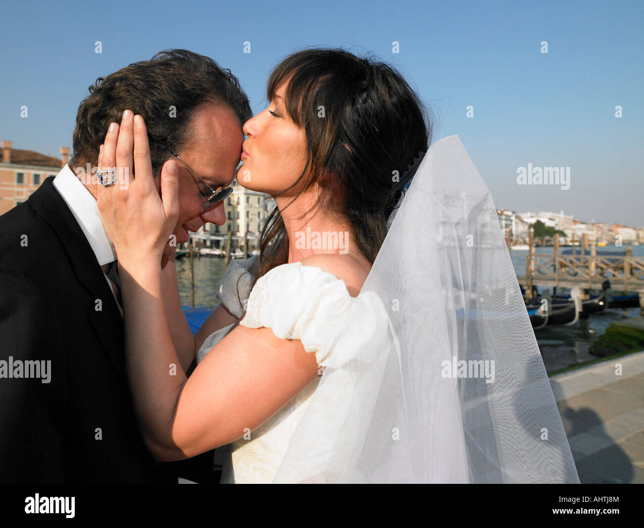 Sposa baciare lo sposo di fronte. Grand Canal, Venezia, Italia. Foto Stock