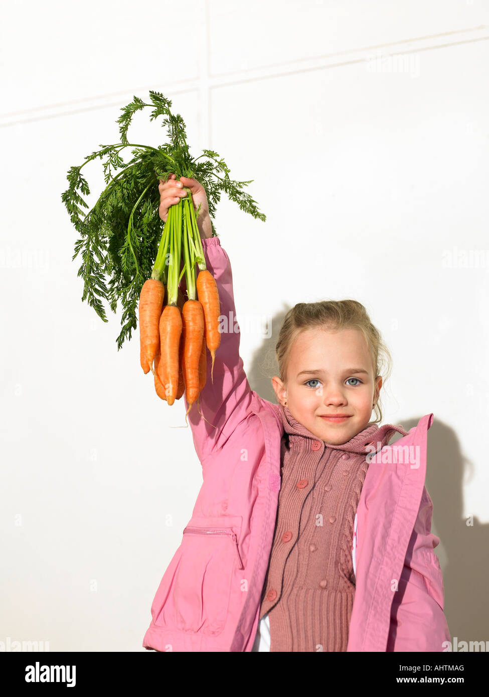 La ragazza (5-7) azienda mazzetto di carote, ritratto Foto Stock