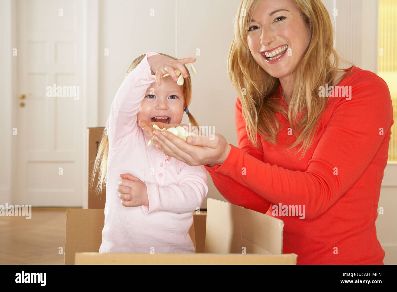 La ragazza (3-5) giocando nella casella con la madre sorridente, ritratto Foto Stock