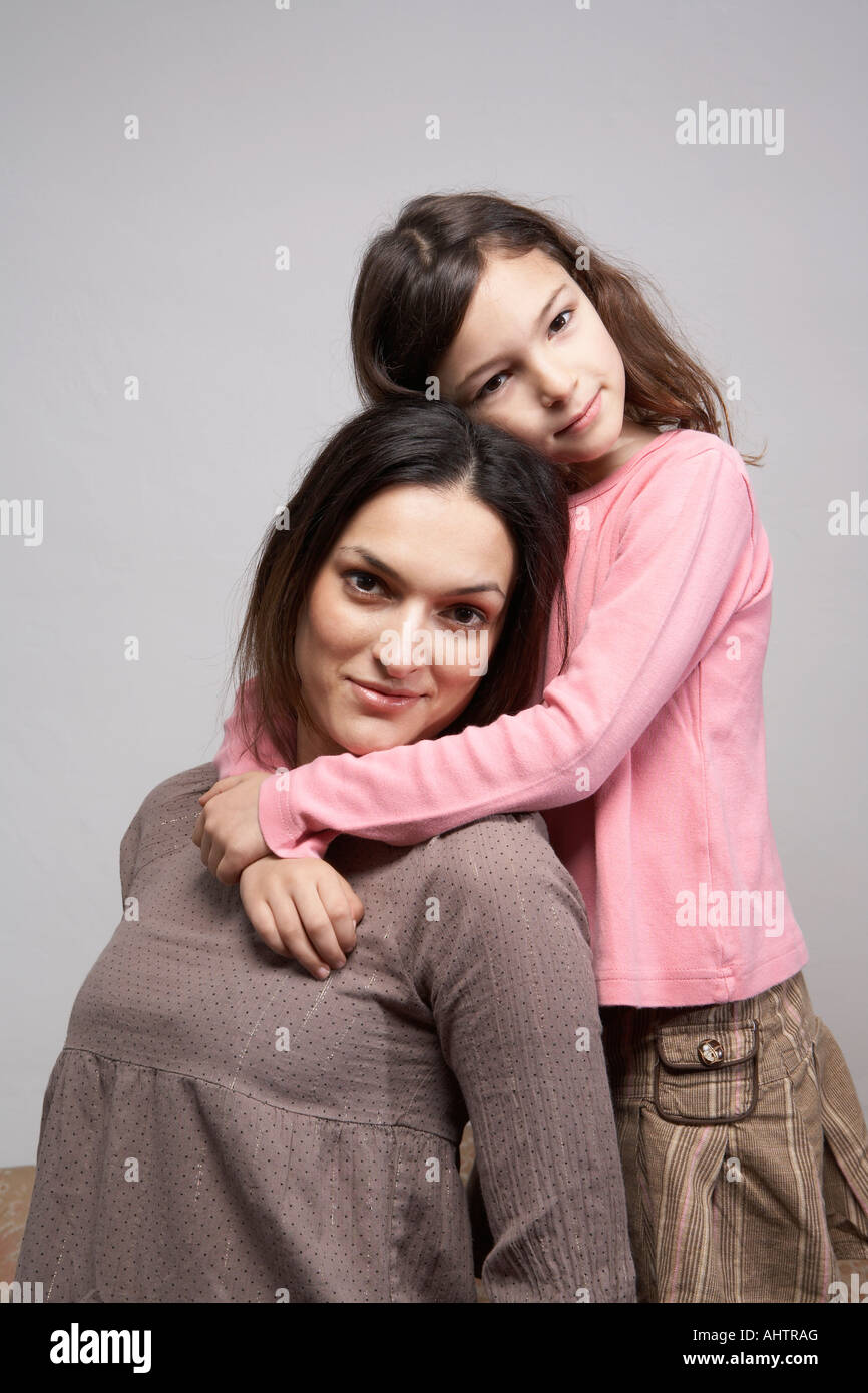 Figlia (5-7)abbracciando la madre, ritratto Foto Stock