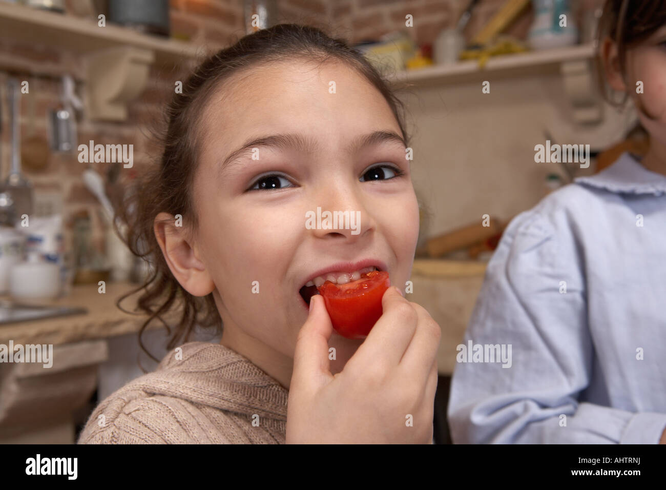 La ragazza (5-7) di mangiare il pomodoro, close-up, ritratto Foto Stock
