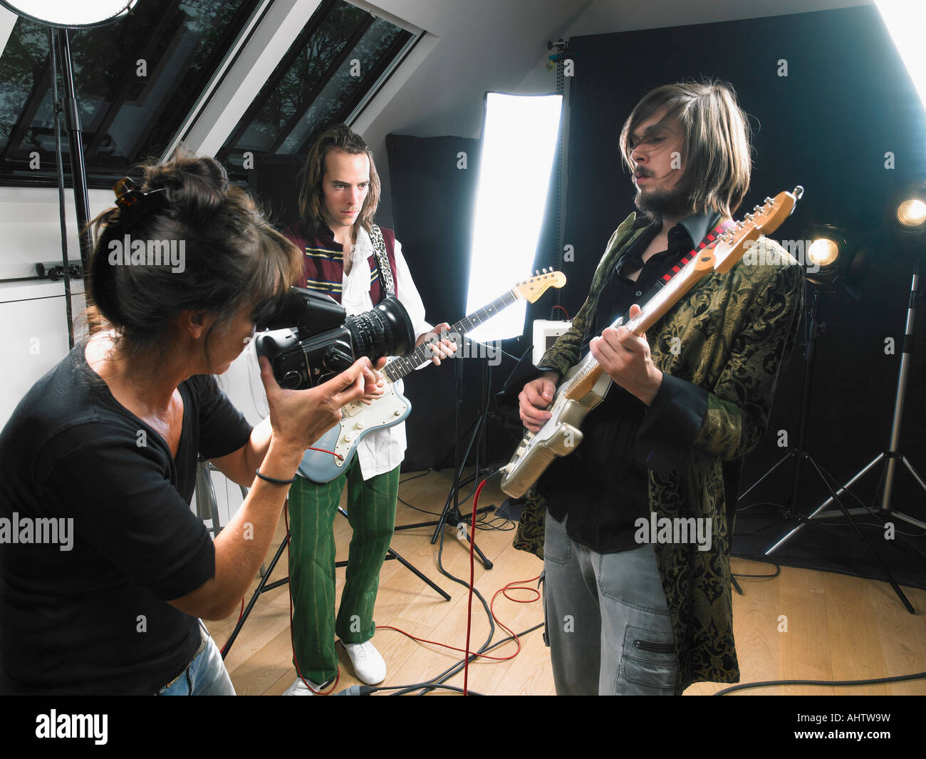 Fotografo femmina a due riprese la chitarra elettrica i giocatori in studio. Foto Stock