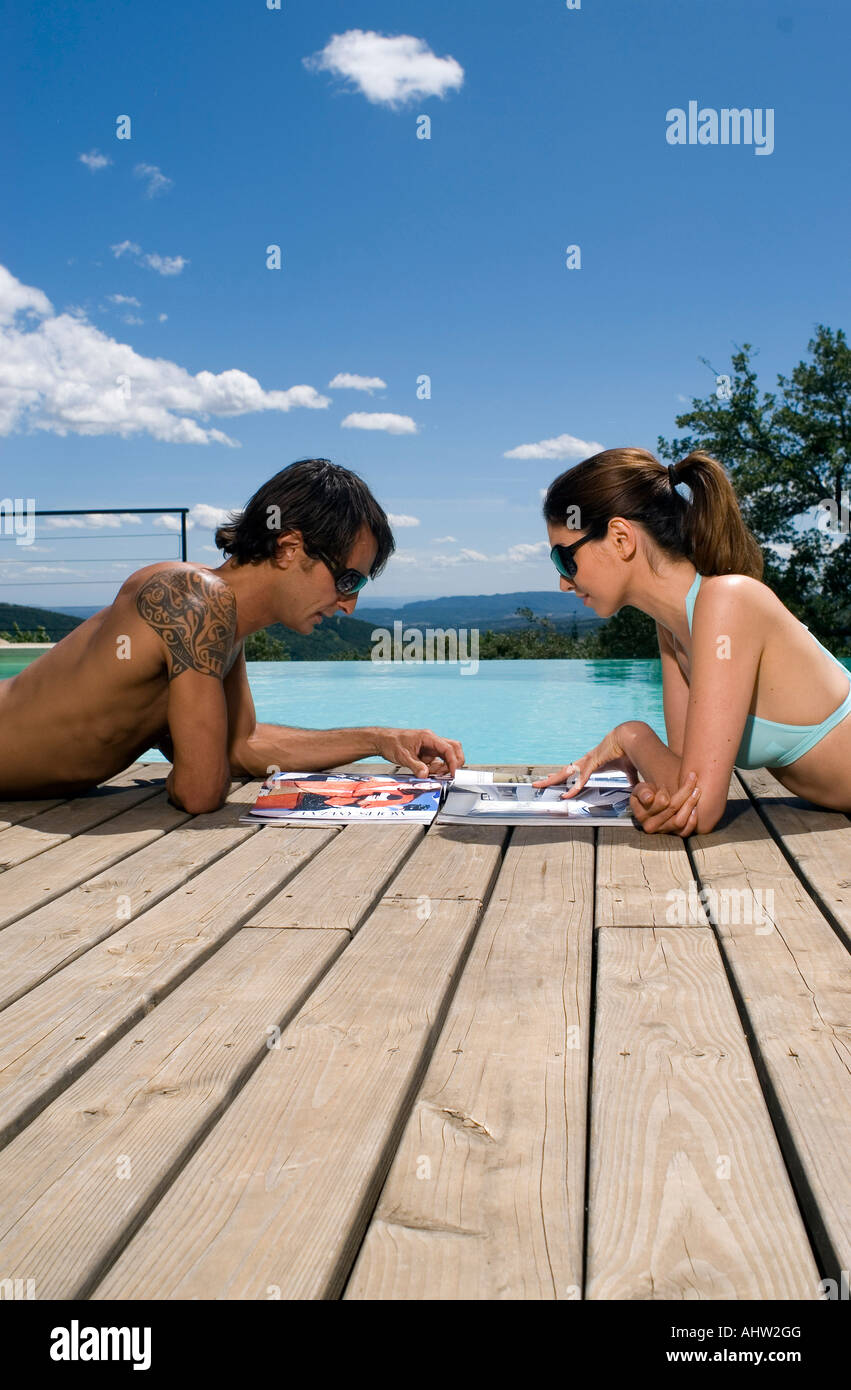 Matura a prendere il sole in una piscina con riviste Foto Stock Matura a prendere il sole in una piscina con riviste Foto Stock