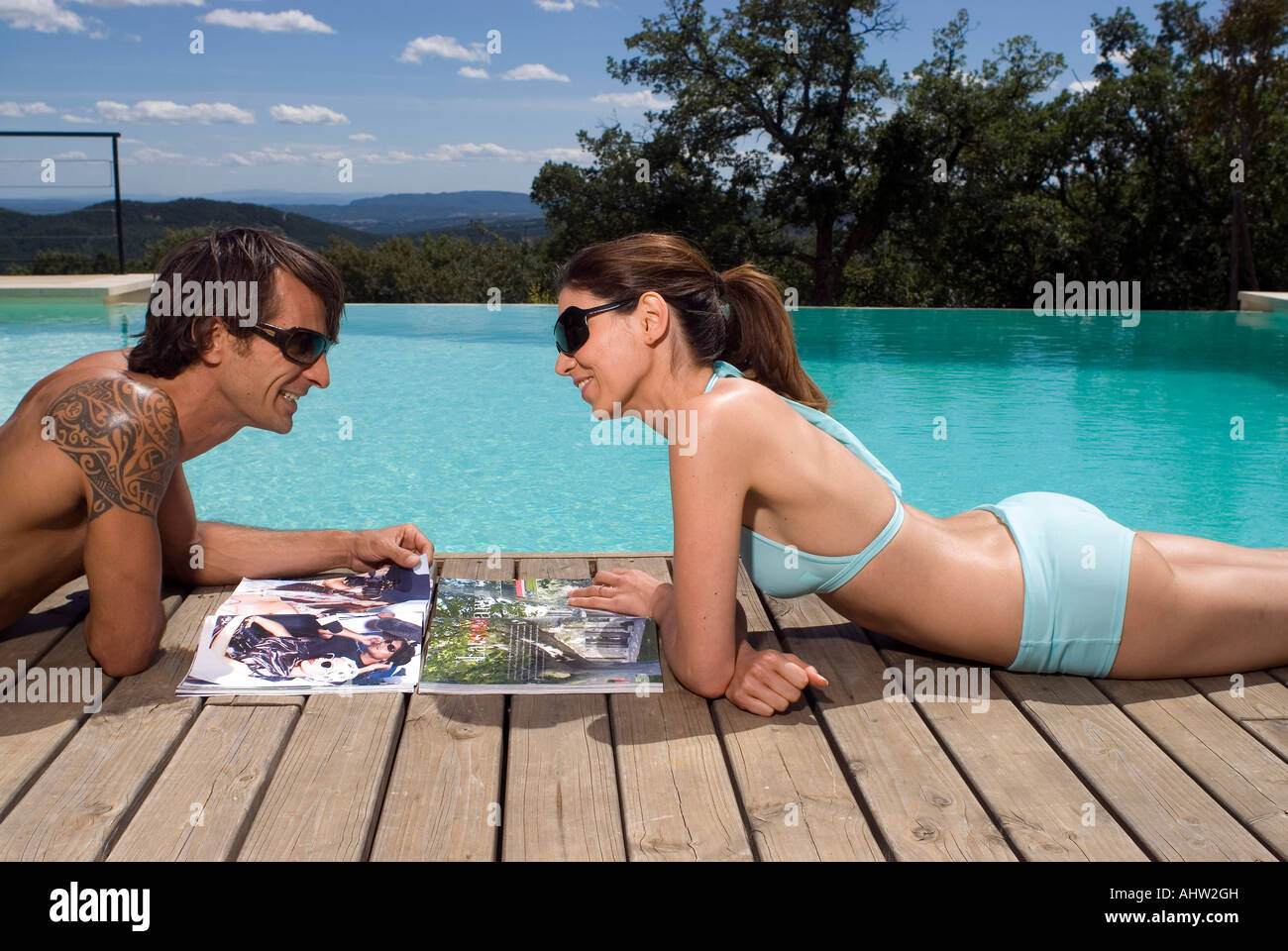 Matura a prendere il sole in una piscina con riviste Foto Stock Matura a prendere il sole in una piscina con riviste Foto Stock