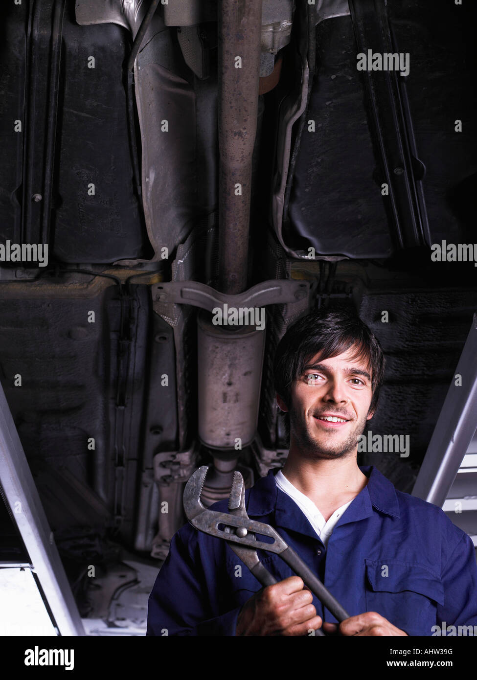 Mechanic sotto una vettura rialzata Foto Stock