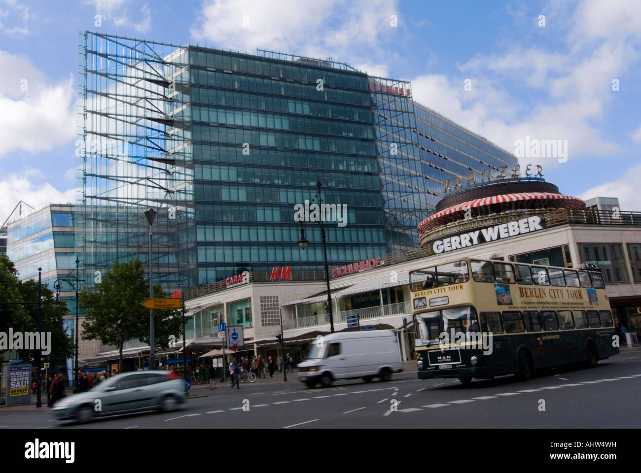 In orizzontale ampia angolazione di Joachimstaler Platz e la facciata in vetro e acciaio del Neues Kranzler Eck in una giornata di sole. Foto Stock