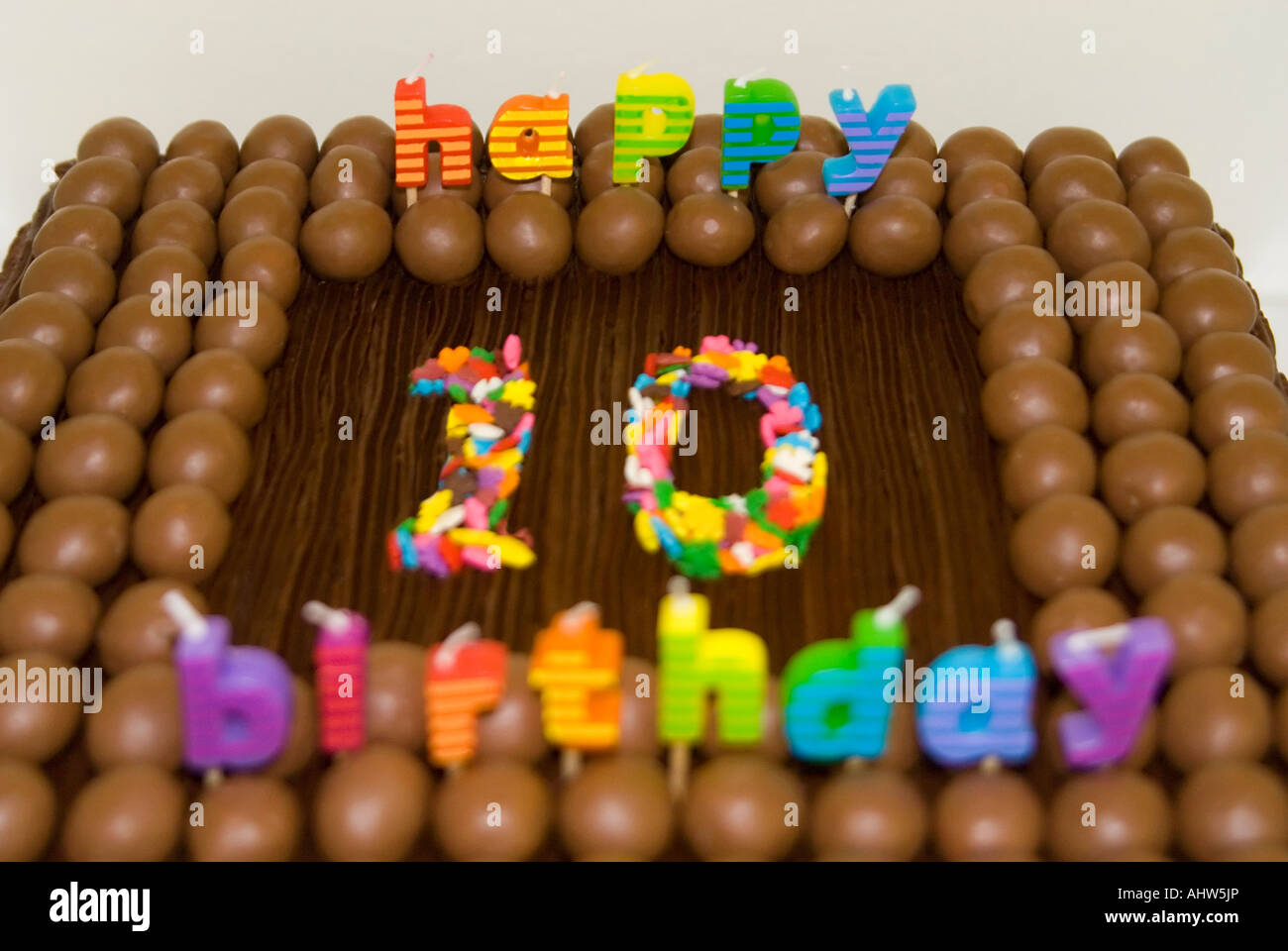 Chiudere orizzontale di un bambino del decimo compleanno torta decorata con dolci al cioccolato, glassa e candele Foto Stock