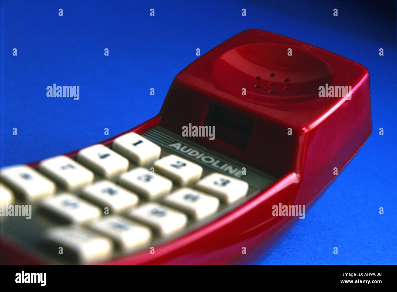 Ricevitore telefonico rosso su sfondo blu Foto Stock