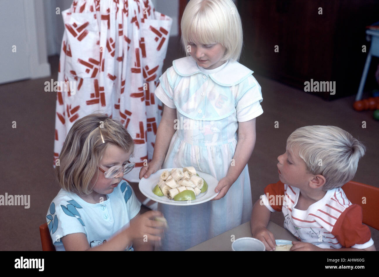 Bambino biondo che serve frutta nella scuola materna Foto Stock
