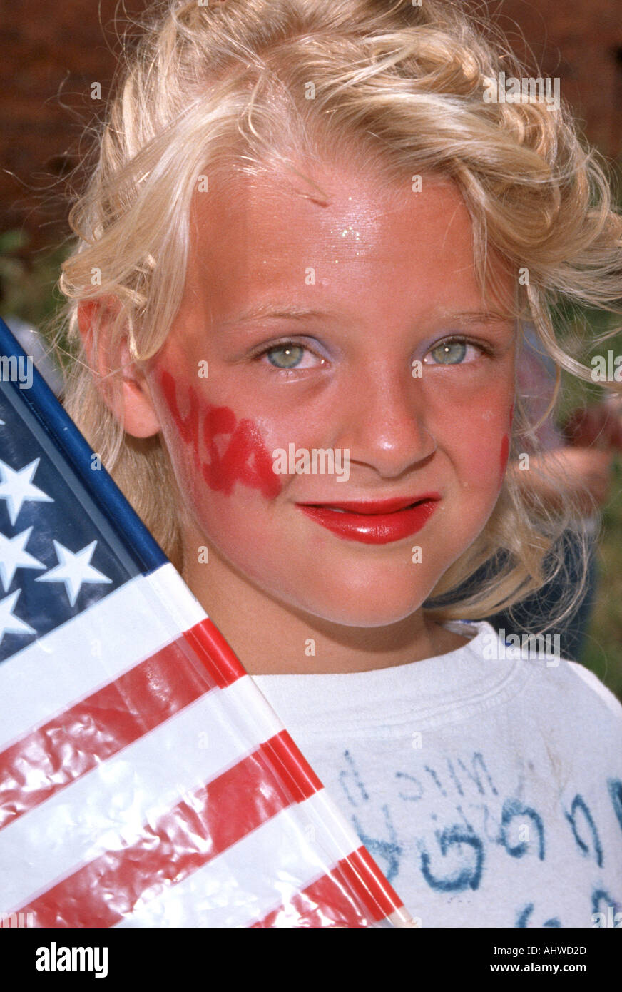 8 anno femmina vecchia raffigura un tema patriottico con una bandiera e faccia dipinta Foto Stock