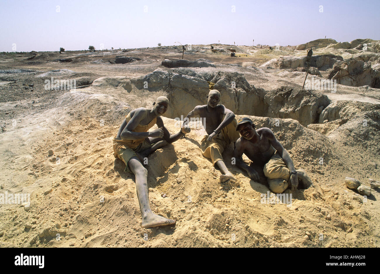 Oro artigianale minatori in appoggio al di sopra del suolo accanto alla loro mano-scavò miniera, un primitivo e pericoloso di ambiente di lavoro a Essakane , Burkina Faso. Foto Stock