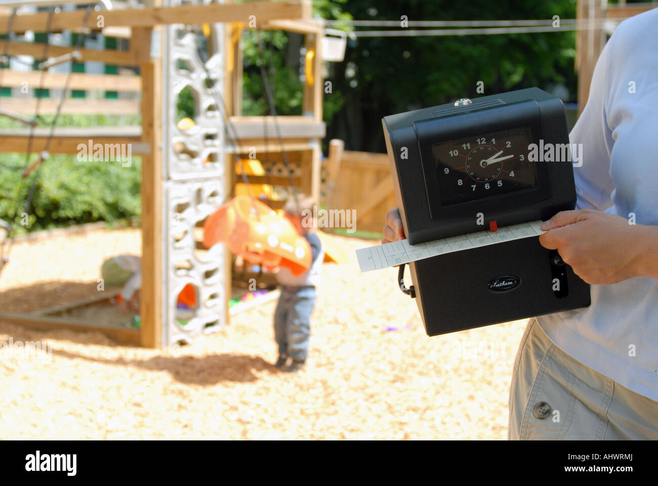 Elettronico orologio tempo detenute da madre nella parte anteriore del parco giochi Foto Stock