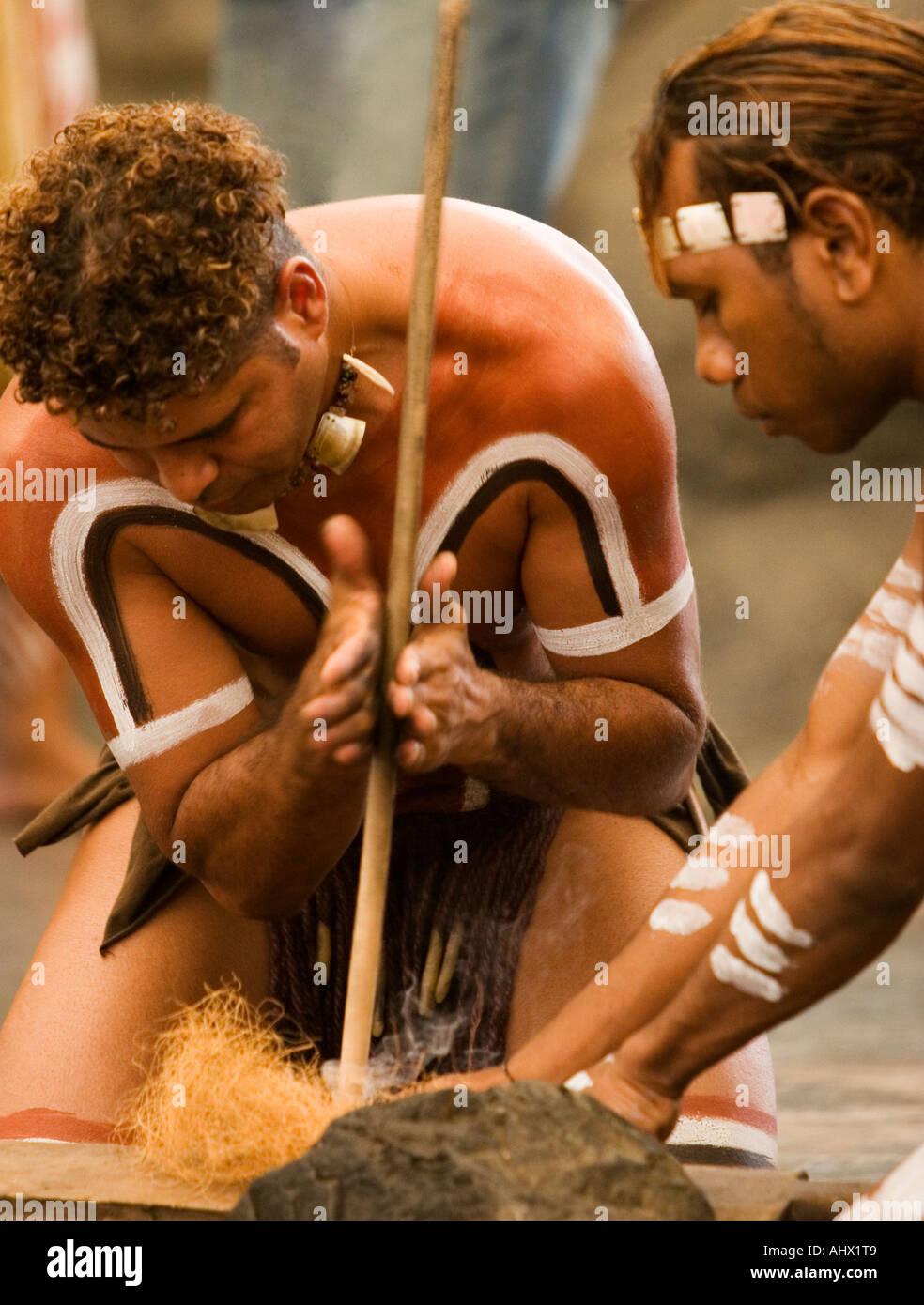Due uomini aborigeni facendo un fuoco usando i metodi tradizionali Foto Stock
