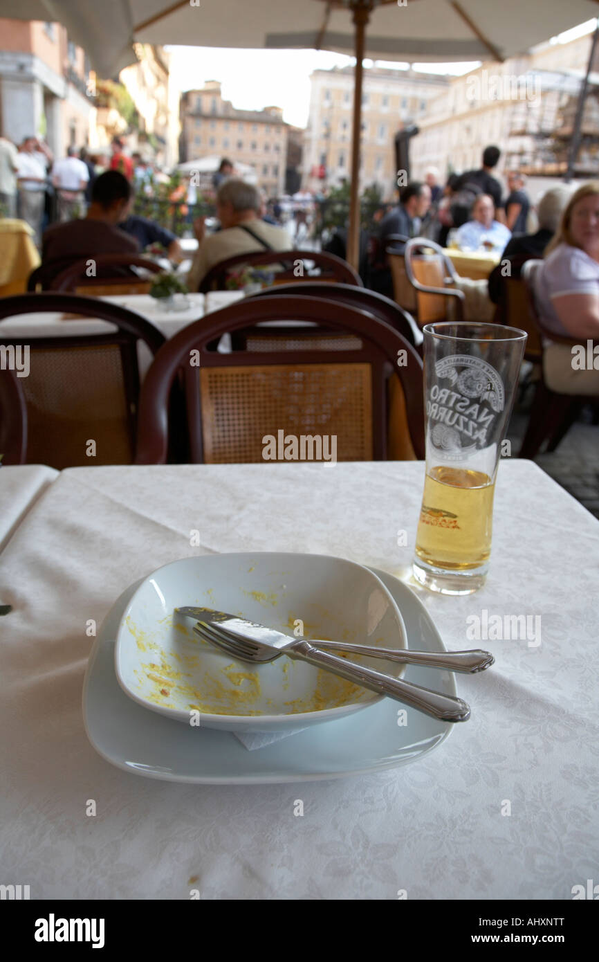 Completamente mangiati ciotola di spaghetti alla carbonara e mezzo bicchiere di birra seduti su un tavolo in un street cafe in Piazza Navona Foto Stock