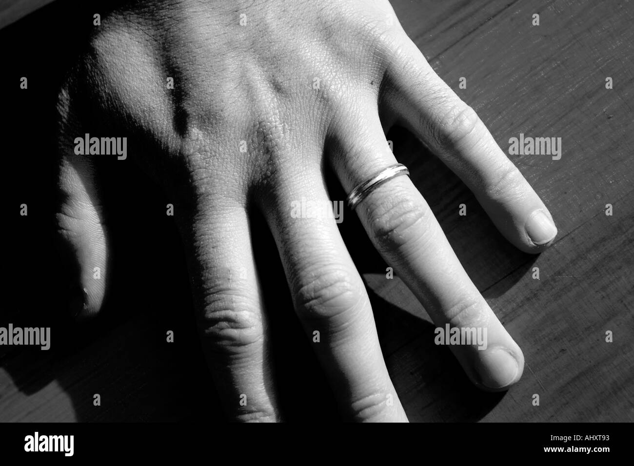 Uomo con le sue mani incrociate sulla tabella che mostra il suo anello di nozze in bianco e nero Foto Stock Uomo con le sue mani incrociate sulla tabella che mostra il suo anello di nozze in bianco e nero Foto Stock