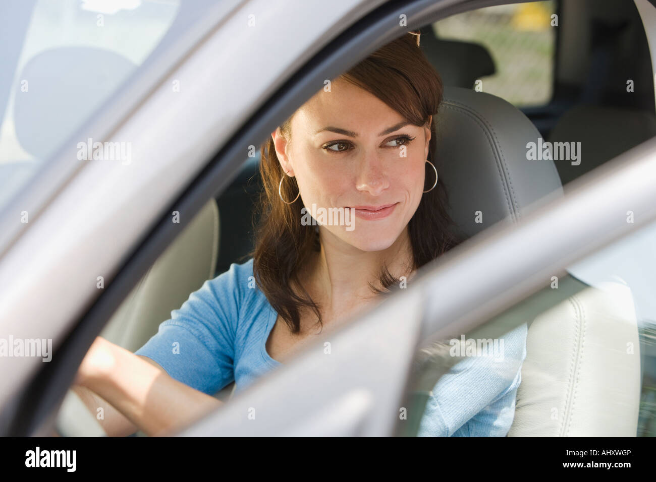 Giovane donna nel lato conducente di auto Foto Stock