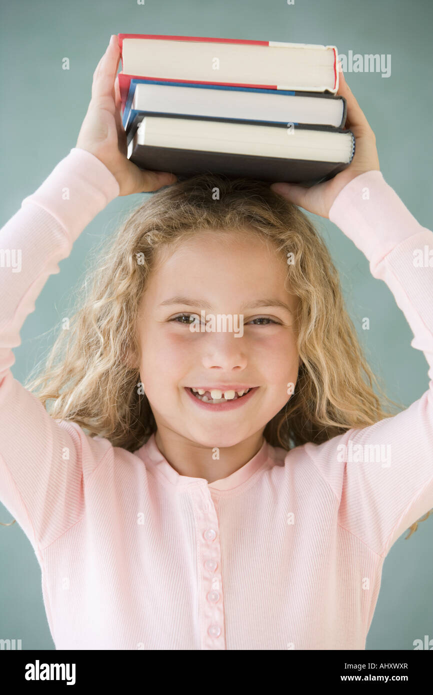 Ragazza con pila di libri sulla testa Foto Stock