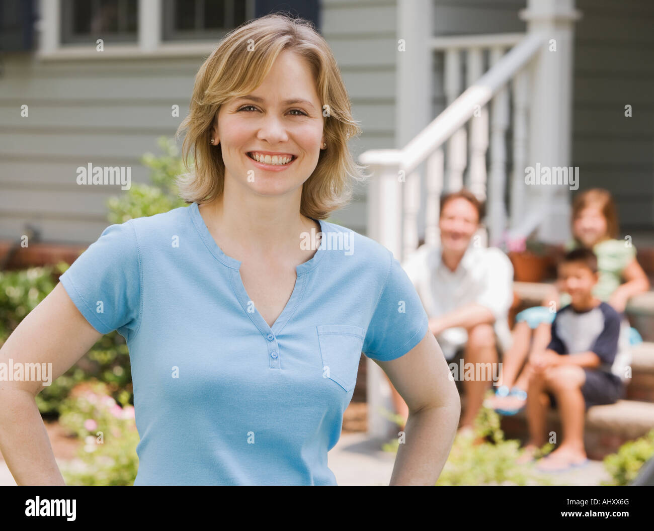 Ritratto di donna con la famiglia in background Foto Stock