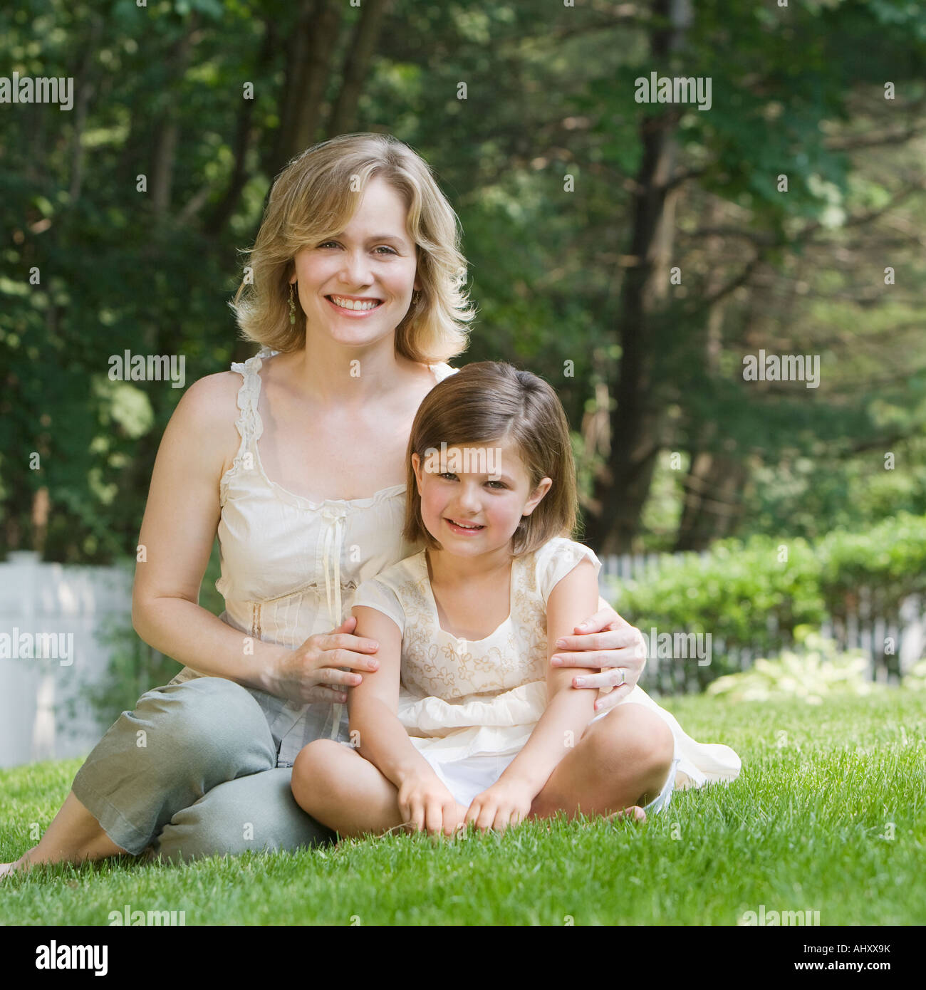 Madre e figlia abbracciando in erba Foto Stock