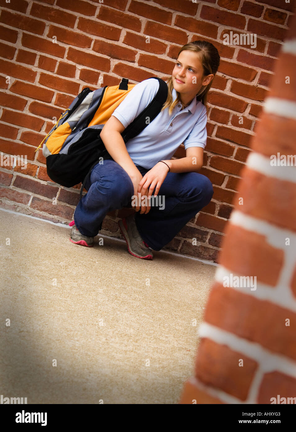 Ragazza in uniforme scolastica tenendo uno zaino Foto Stock