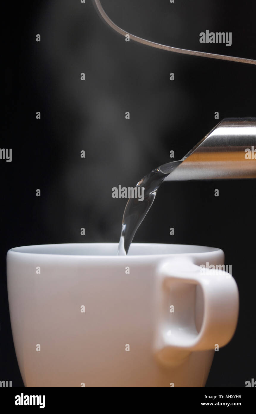Persona colata di tazza di acqua calda in tazza Foto Stock