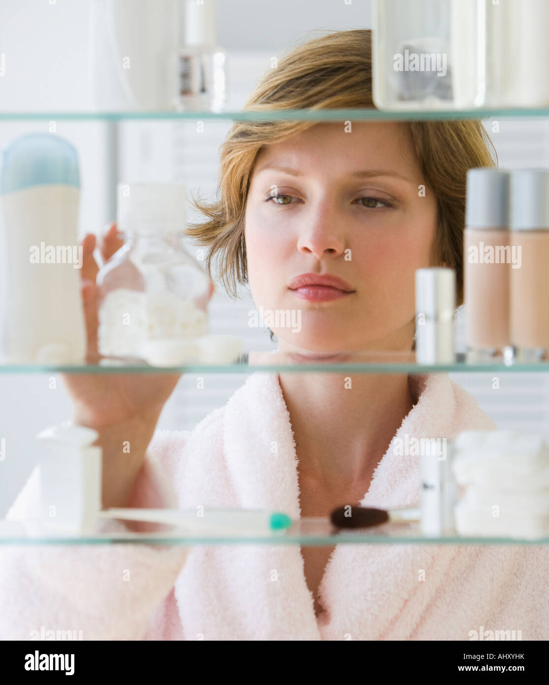 Donna che guarda in medicina cabinet Foto Stock