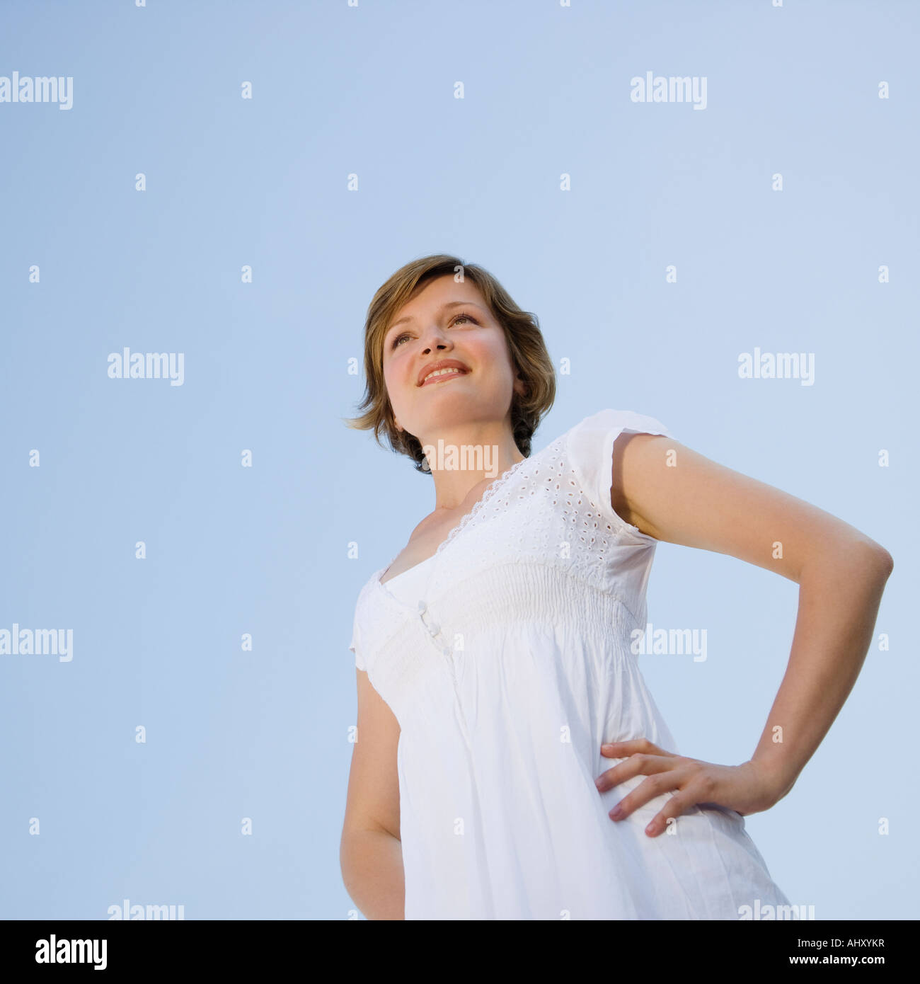 Basso angolo di visione della donna con le mani sui fianchi Foto Stock