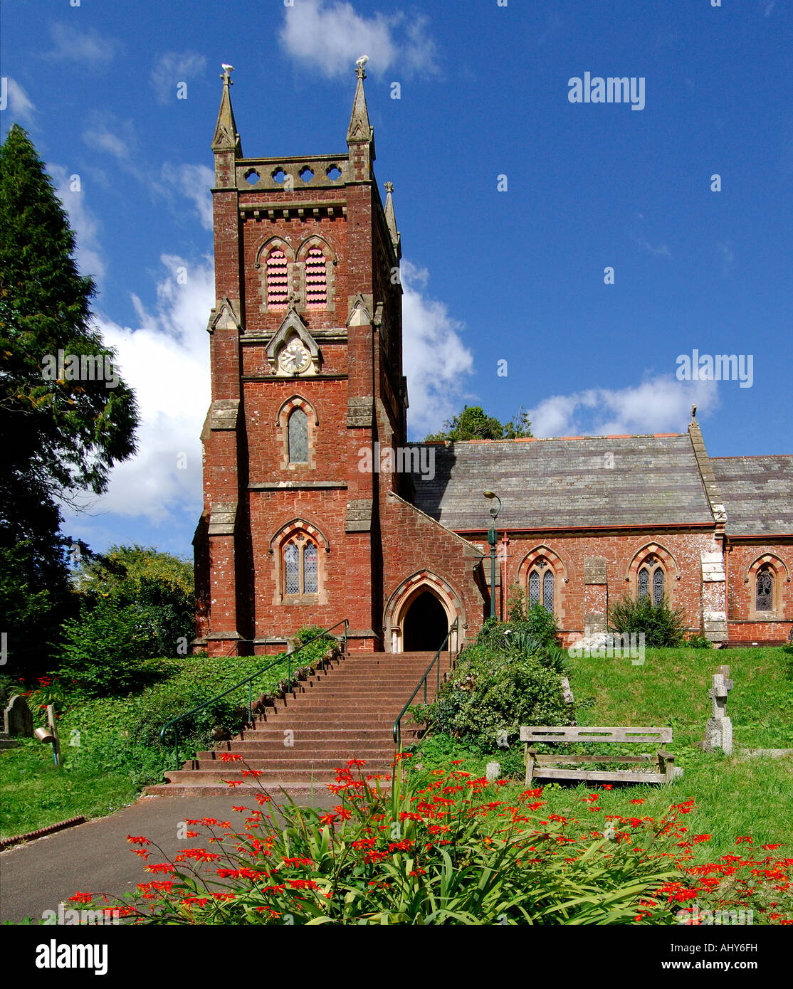 Pietra arenaria rossa costruito la chiesa al Collaton St Mary vicino a Paignton South Devon England su un luminoso giorno di estate Foto Stock