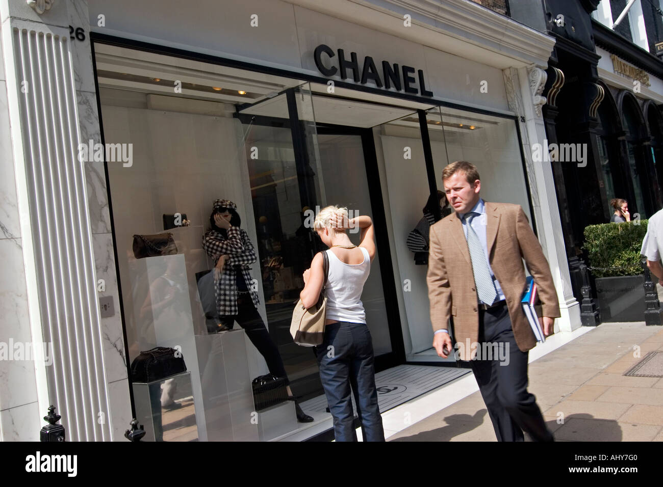 Giovane donna guarda in Chanel designer store window su Bond Street Foto Stock