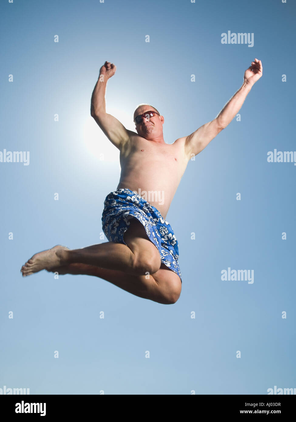 Uomo in costume da bagno jumping Foto Stock