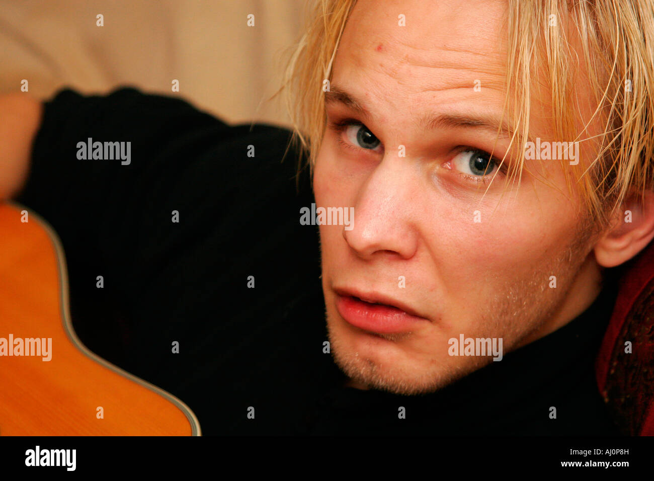 Giovane maschio con la chitarra. Capelli biondi Boy Foto Stock