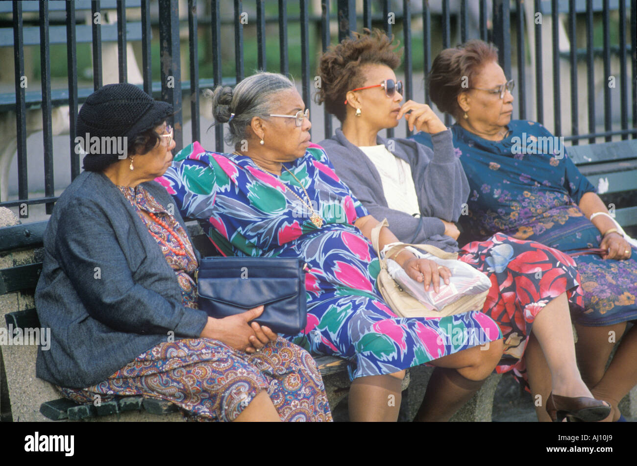 Quattro americano africano donna seduta su una panchina nel parco Foto Stock