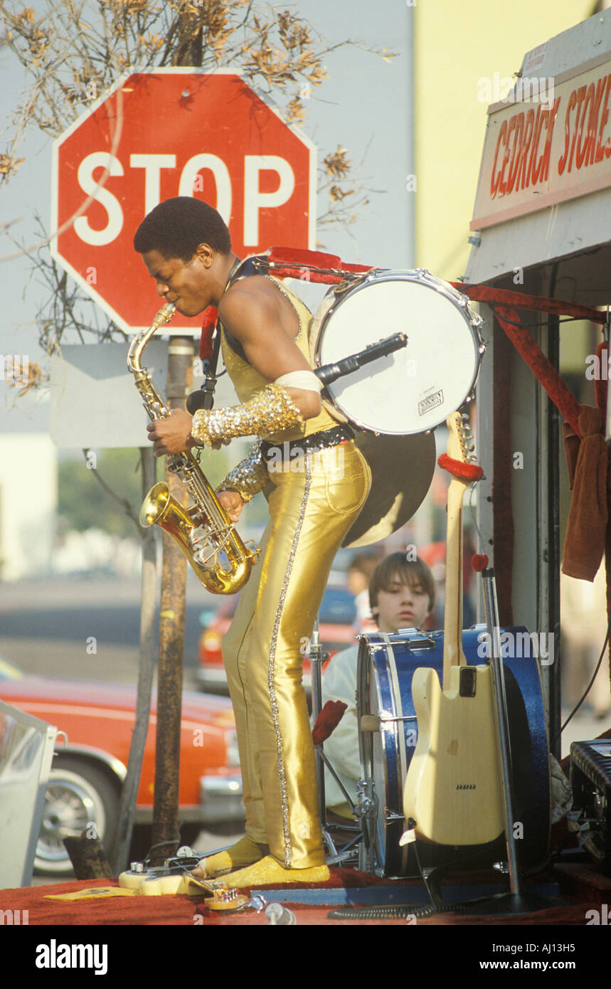 Un one man band in un oro costume di Lamè di eseguire sulla strada Venezia CA Foto Stock