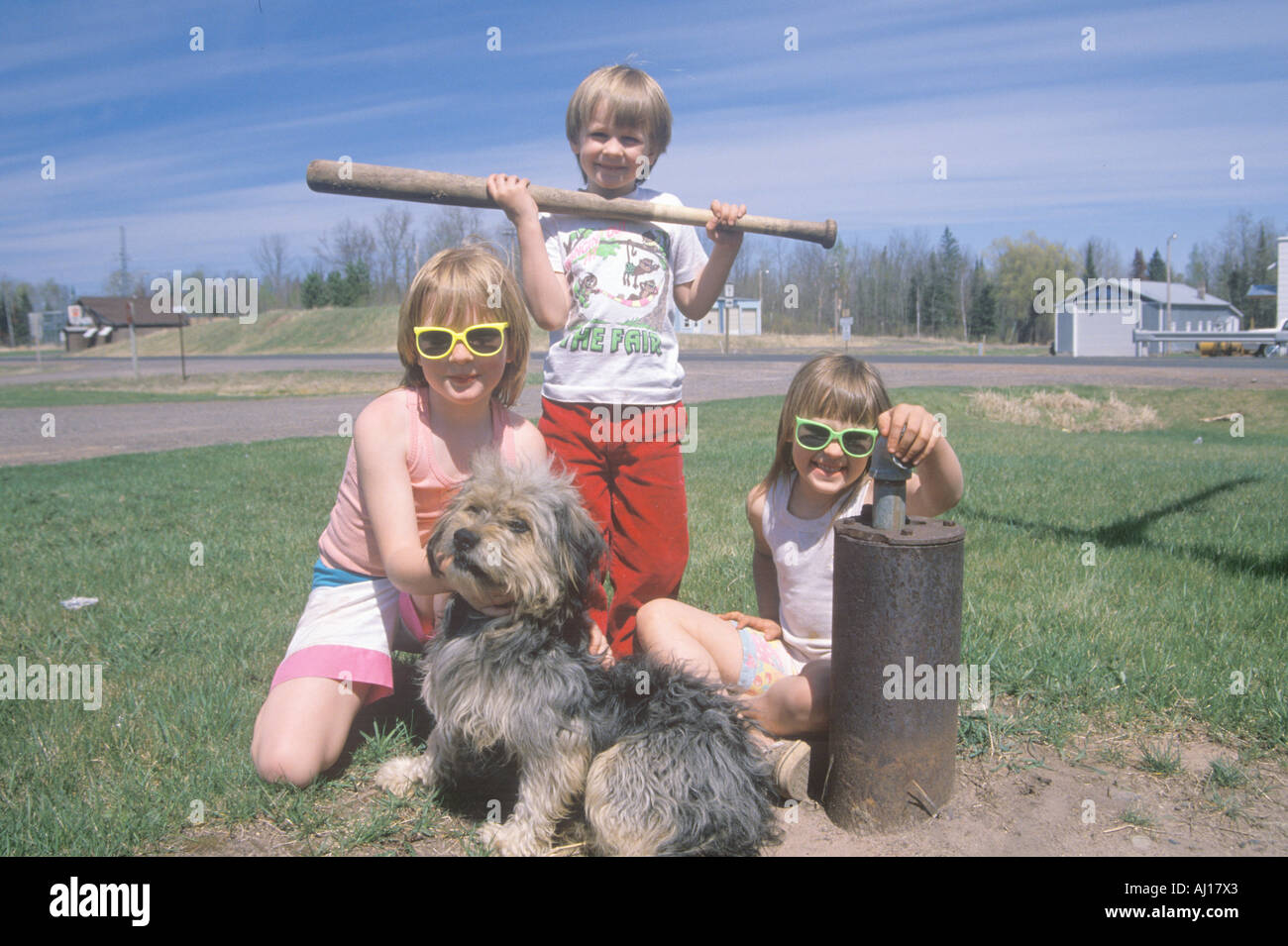 Tre bambini con il loro cane in riproduzione in Dairyland WI Foto Stock