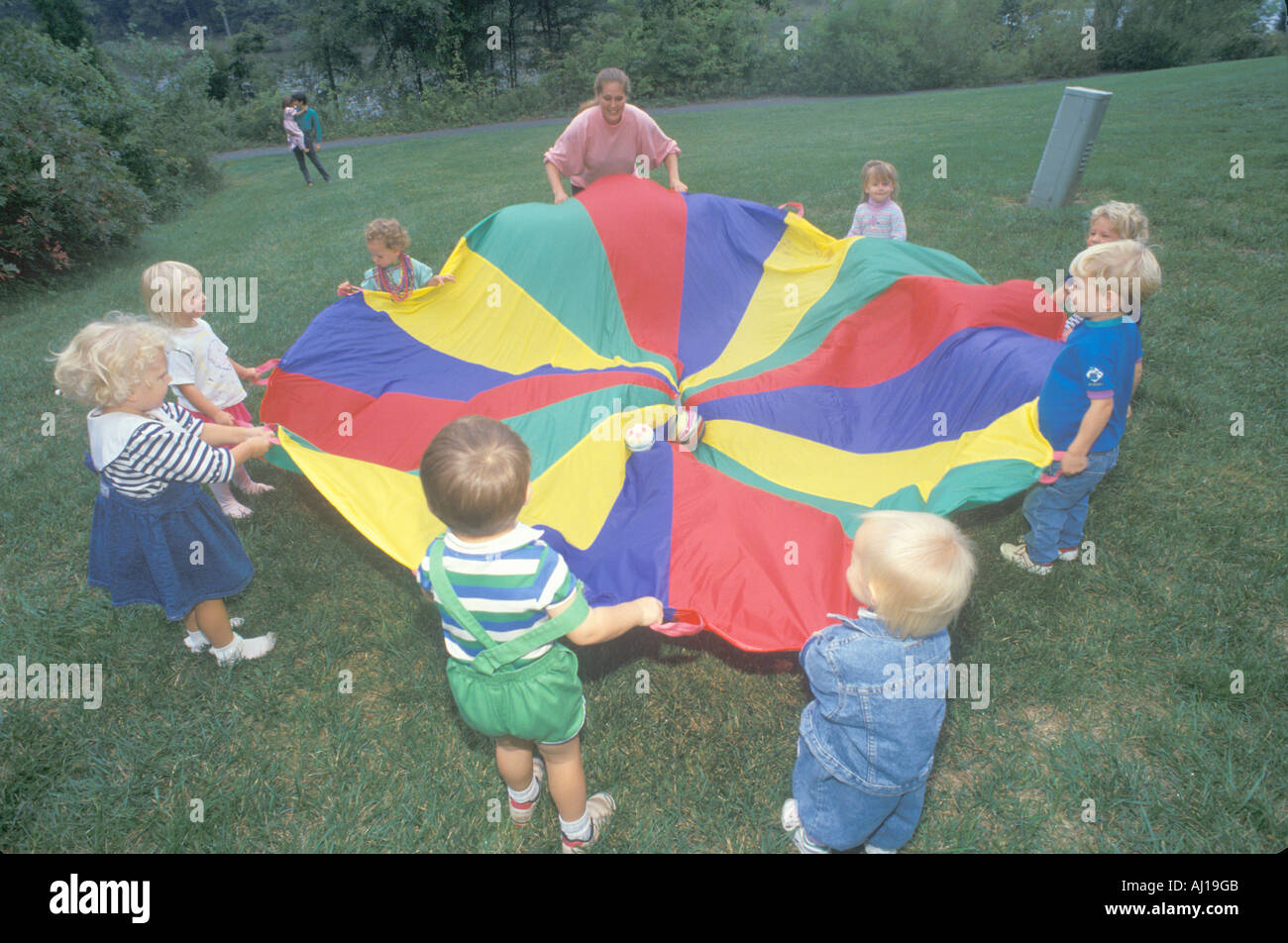 Asilo nido i bambini a giocare un gioco di paracadute Foto stock - Alamy
