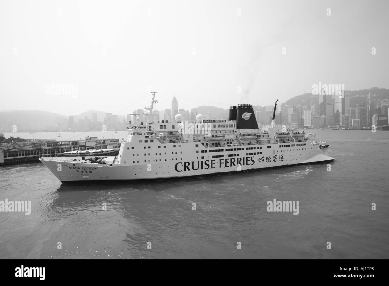 Asia Repubblica popolare cinese Hong Kong rimorchiatori escort nave da crociera M V Wasa Queen vele da ormeggio lungo waterfront Foto Stock