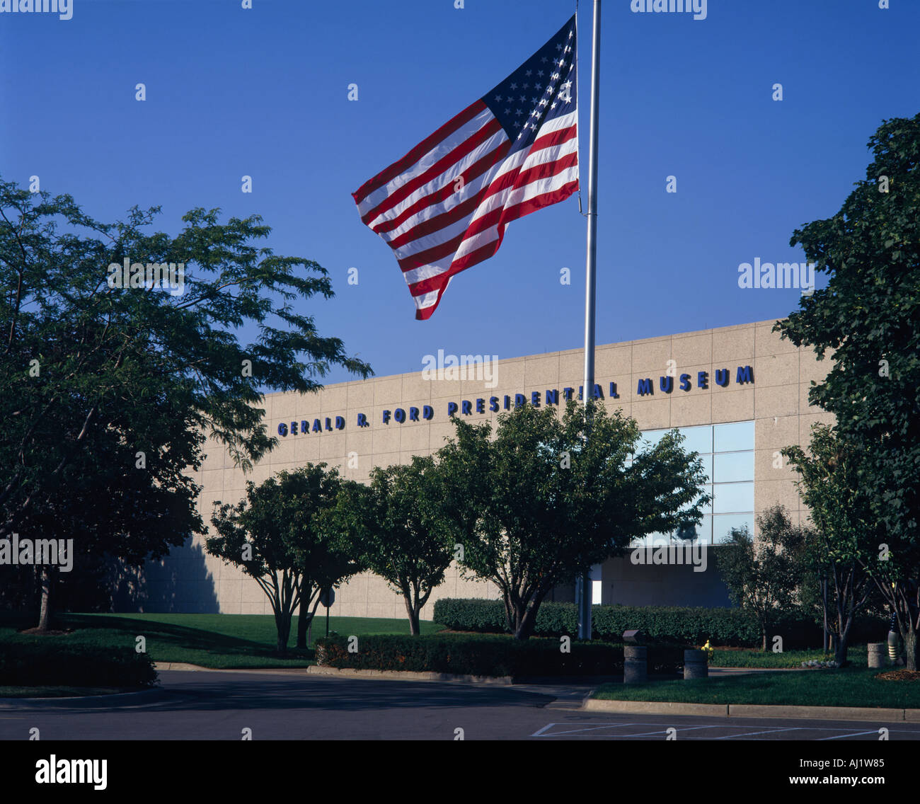 La pietra e la parete di vetro frontale del Gerald R Ford museo presidenziale alberi cielo blu Grand Rapids Michigan STATI UNITI Foto Stock