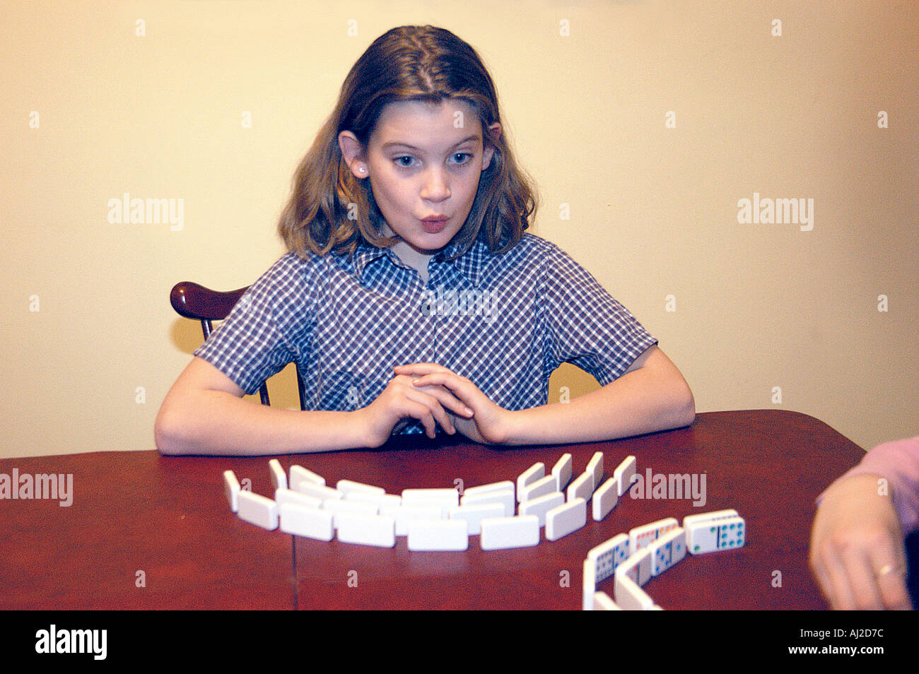 Ragazza che gioca domino con look quizzical Foto Stock