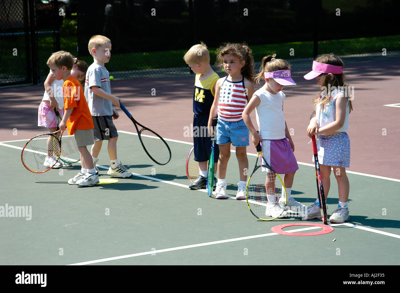 I ragazzi imparano a giocare a tennis presso il pubblico corte di ricreazione Foto Stock